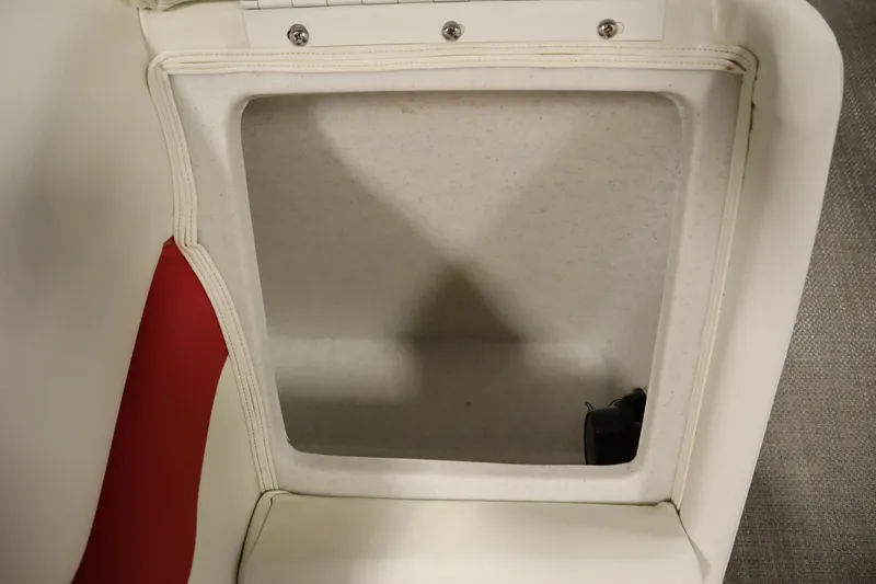 Slide: The Image of Open storage compartment in 2014 JC 22 Limited boat seat, featuring white and red upholstery. - 39