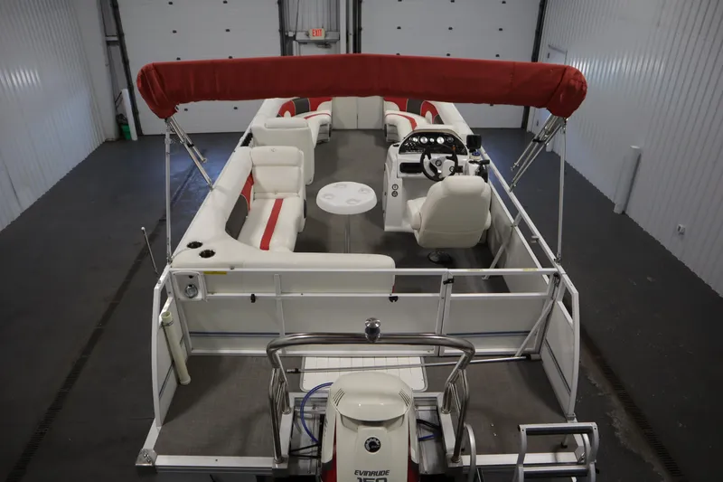 Slide: The Image of 2014 JC 22 Limited pontoon boat with red canopy and spacious seating in a garage. - 9