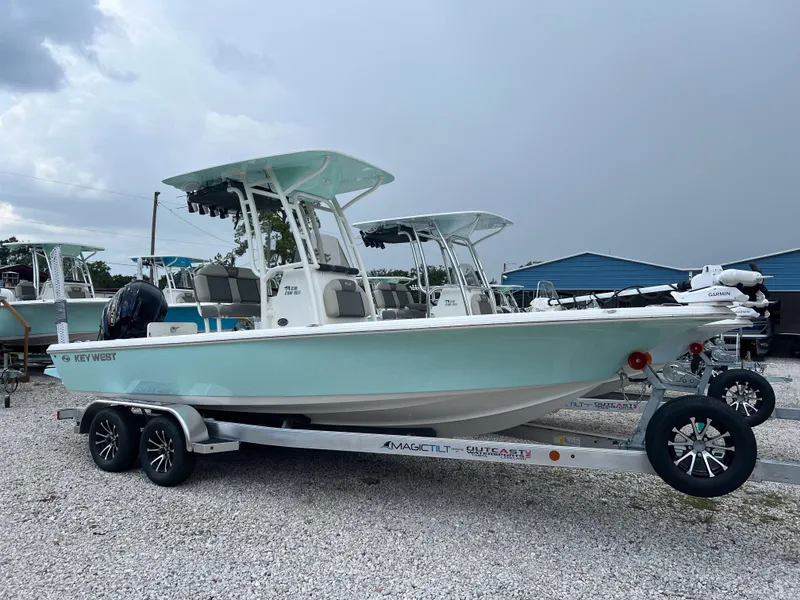 The Image of 2026 Key West 230 Bay Reef boat on trailer, parked outdoors under cloudy sky. - 0