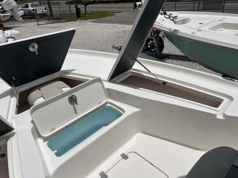 Slide: The Image of 2026 Key West 230 Bay Reef boat with open storage compartments and seating area. - 2
