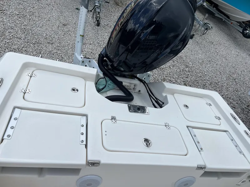 Slide: The Image of 2026 Key West 230 Bay Reef boat with outboard motor, white deck, and storage compartments. - 9