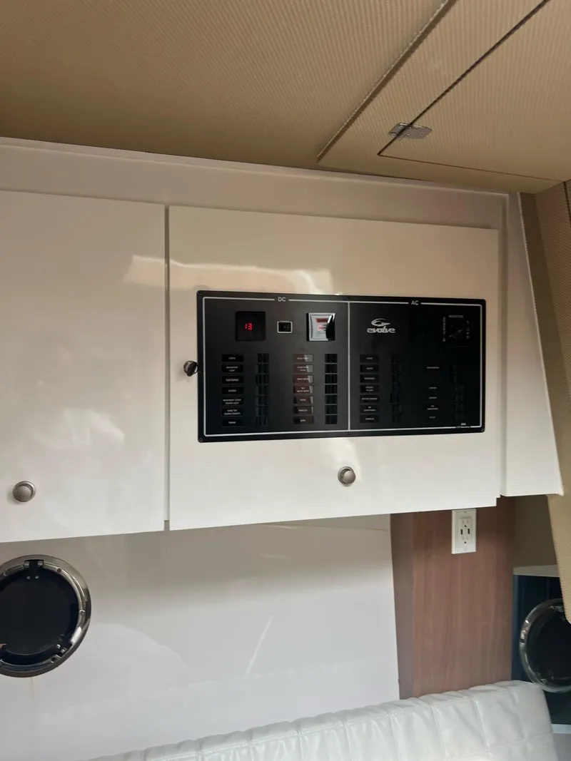 Slide: The Image of Control panel of 2022 Evolve 400HT boat, featuring AC and DC switches. - 14