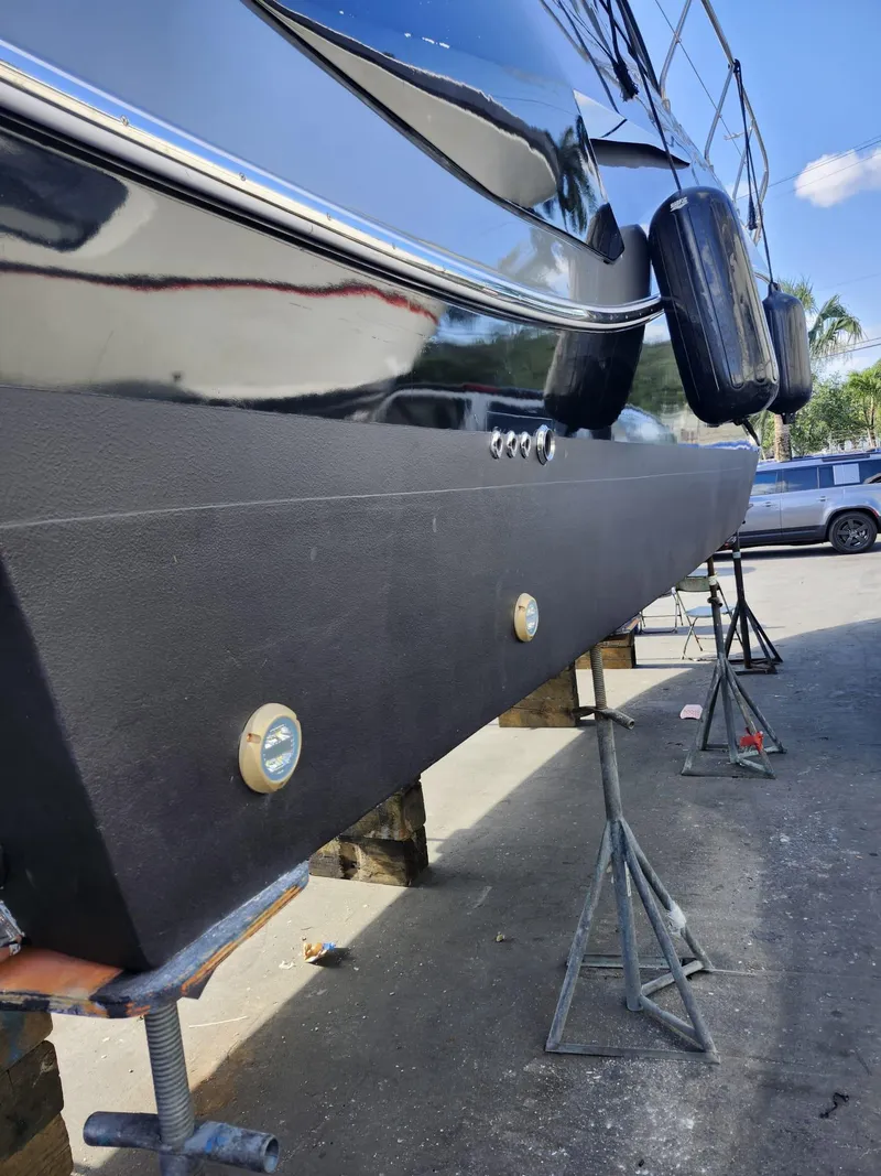 Slide: The Image of 2022 Evolve 400HT yacht on stands, black hull, outdoor setting. - 24