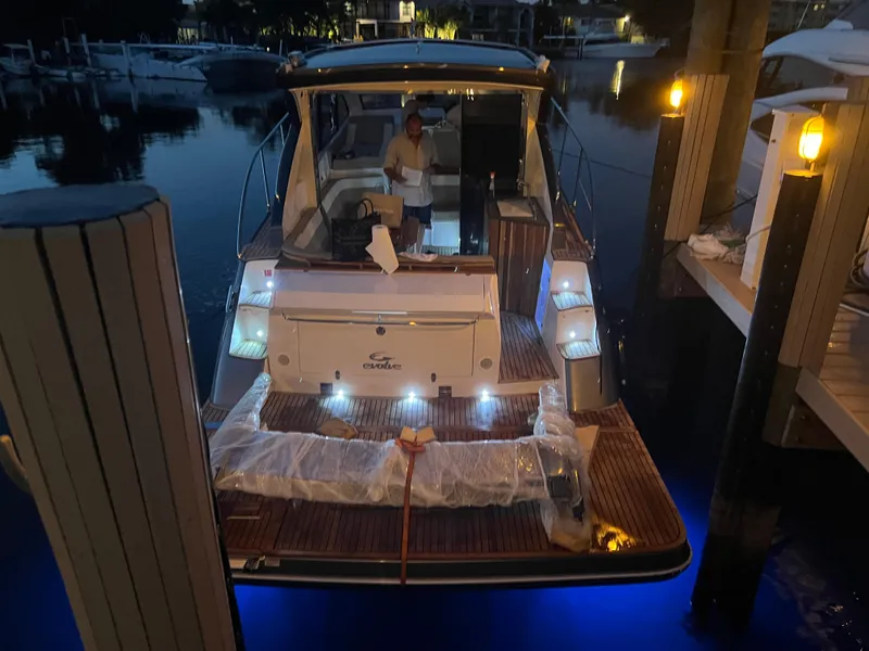 Slide: The Image of Evolve 400HT 2022 yacht docked at night with illuminated deck and person onboard. - 26