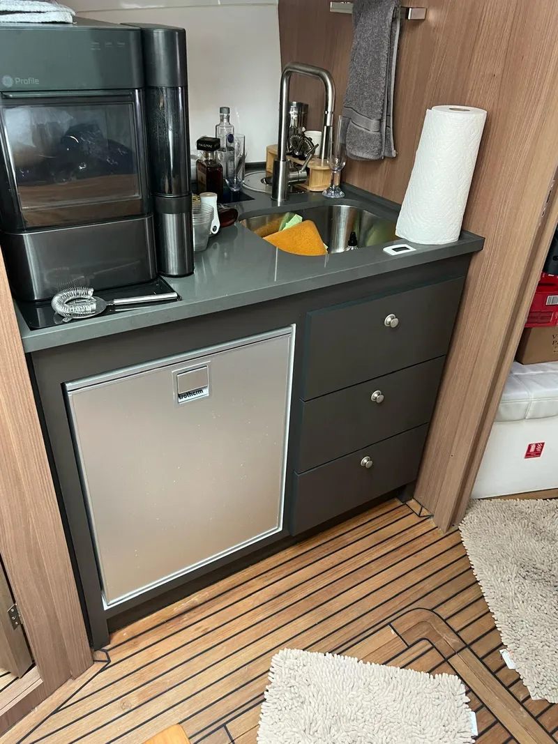 Slide: The Image of Compact kitchen area in 2022 Evolve 400HT yacht with sink, fridge, and coffee maker. - 12