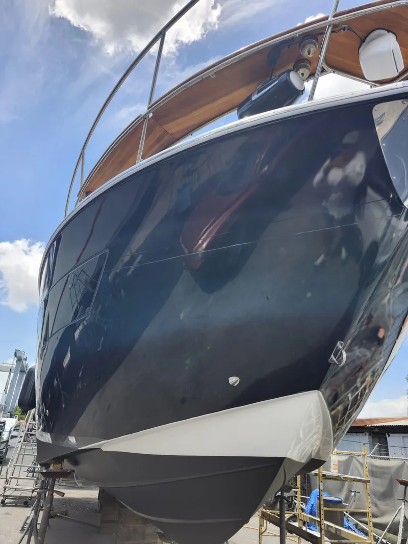 Slide: The Image of 2022 Evolve 400HT yacht, sleek design, docked under blue sky. - 21