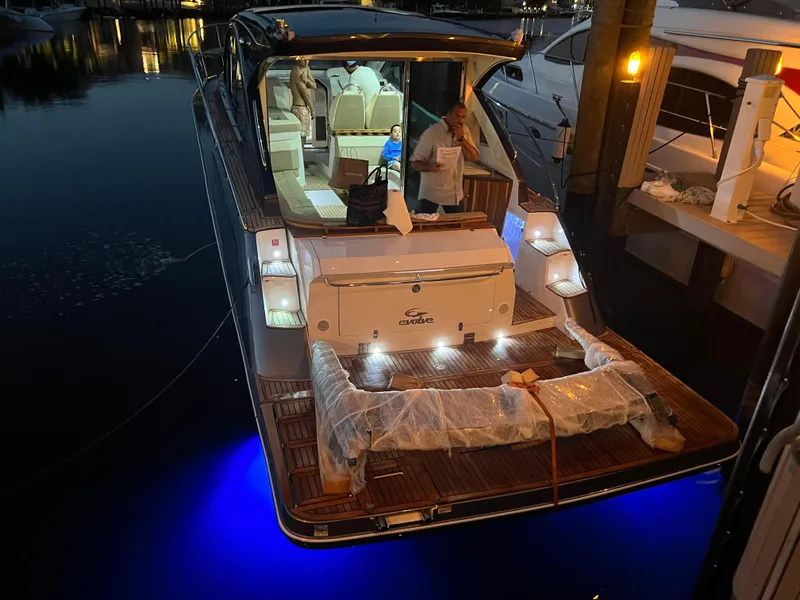 Slide: The Image of Evolve 400HT 2022 yacht docked at night with blue underwater lights. - 27