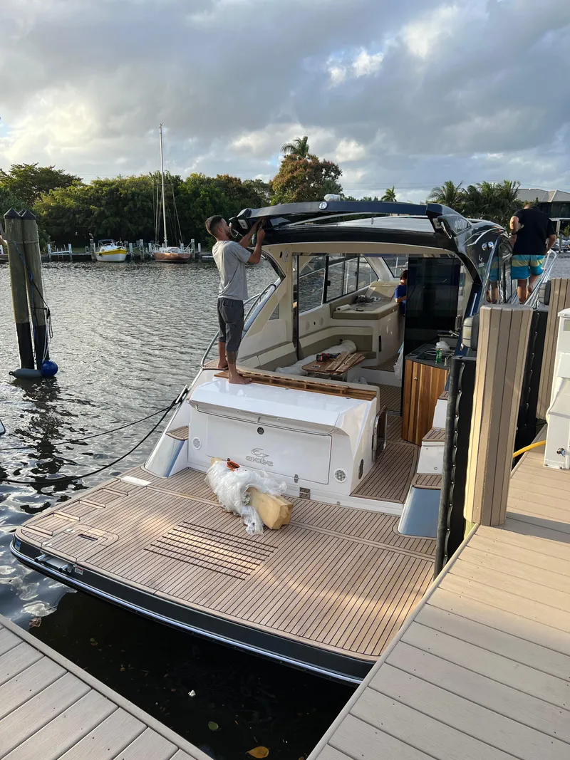 Slide: The Image of Man working on 2022 Evolve 400HT yacht docked by a scenic waterfront. - 28