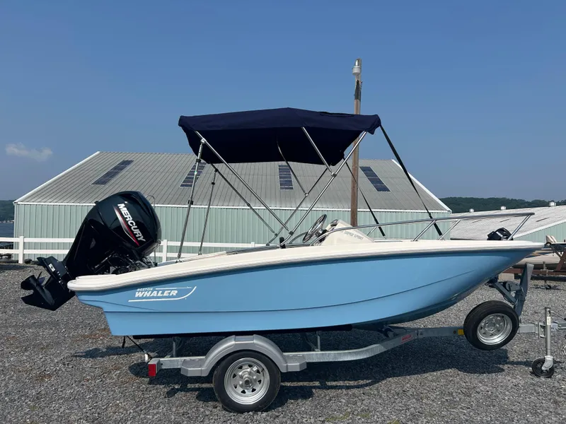 The Image of 2025 Boston Whaler 130 Super Sport boat with Mercury engine on trailer, blue hull. - 0