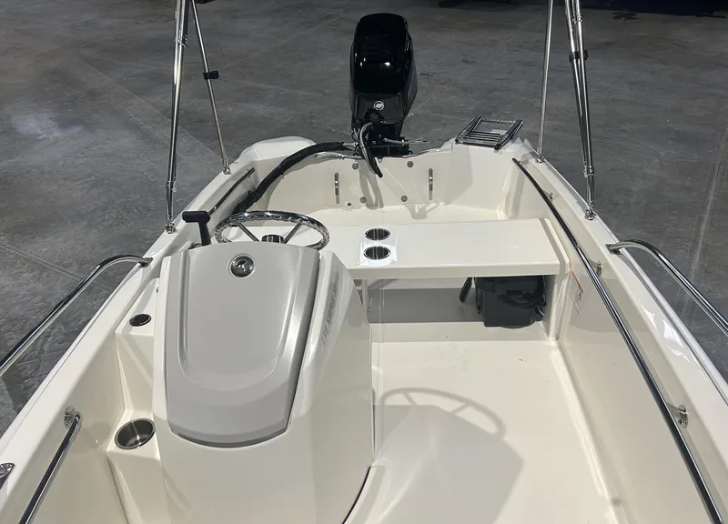 Slide: The Image of 2026 Boston Whaler 130 Super Sport boat interior with steering wheel and seating. - 12