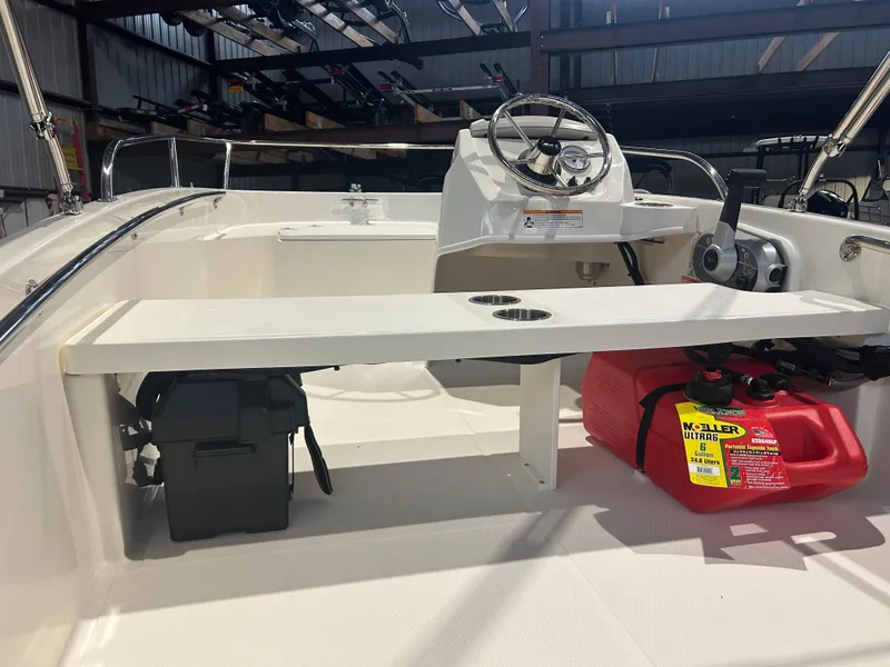 Slide: The Image of 2026 Boston Whaler 130 Super Sport interior with steering wheel and storage compartments. - 17