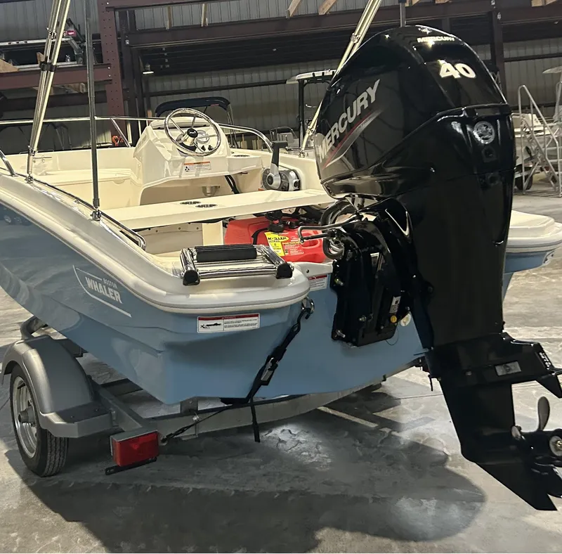 Slide: The Image of 2026 Boston Whaler 130 Super Sport with Mercury 40 engine in a warehouse setting. - 19
