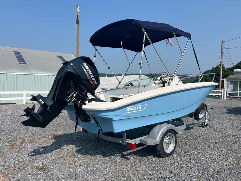 Slide: The Image of 2025 Boston Whaler 130 Super Sport boat with Mercury engine on trailer. - 2