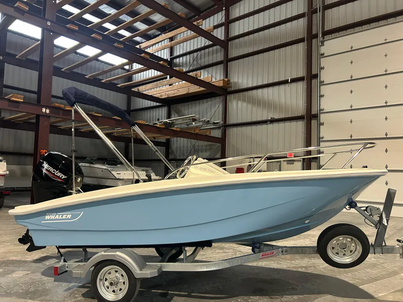 Slide: The Image of 2026 Boston Whaler 130 Super Sport boat in a warehouse, on a trailer. - 20