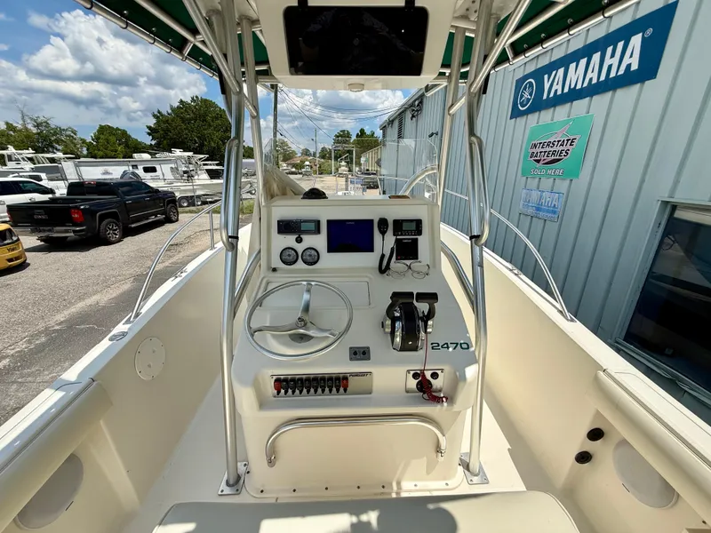 Slide: The Image of 1997 Pursuit 2470 Center Console boat dashboard with steering wheel and controls. - 11