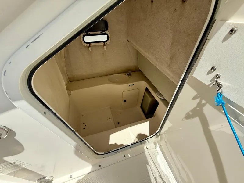 Slide: The Image of 1997 Pursuit 2470 Center Console boat cabin interior with small sink and window. - 14