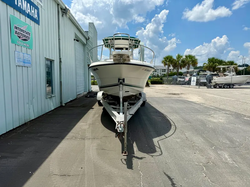 Slide: The Image of 1997 Pursuit 2470 Center Console boat on trailer, parked outside a Yamaha dealership. - 2
