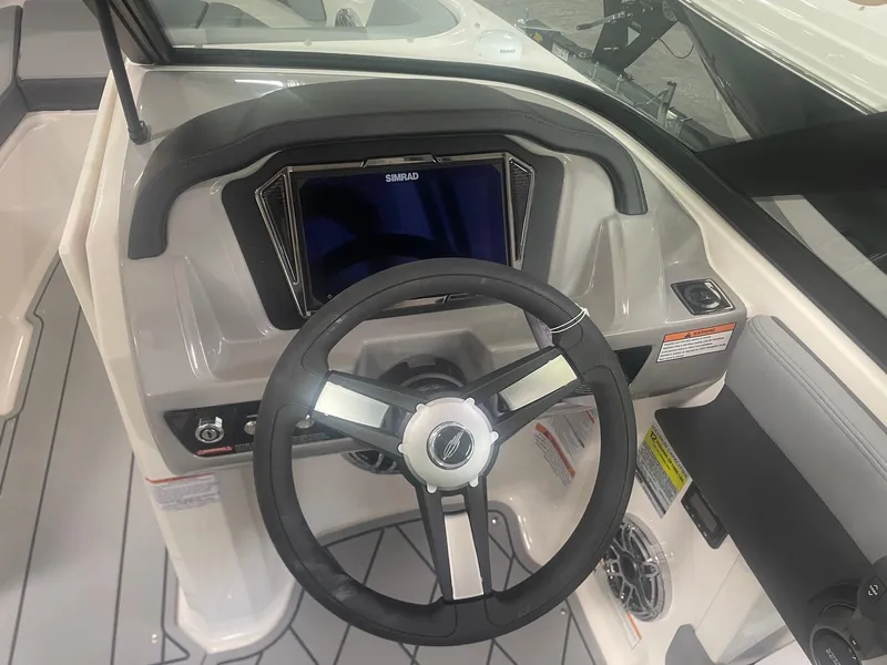 Slide: The Image of 2026 Chaparral GT Surf 1 boat dashboard with steering wheel and Simrad display. - 10