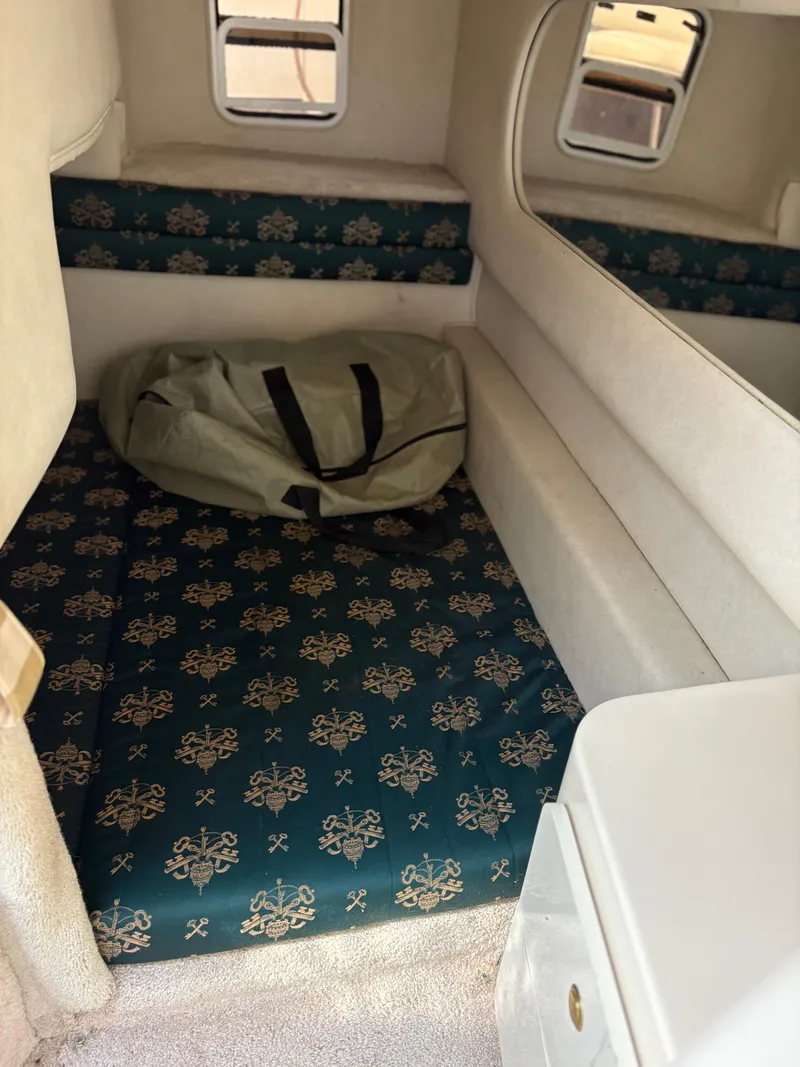 Slide: The Image of 1996 Sea Ray 270 Sundancer cabin interior with patterned cushions and a bag. - 13