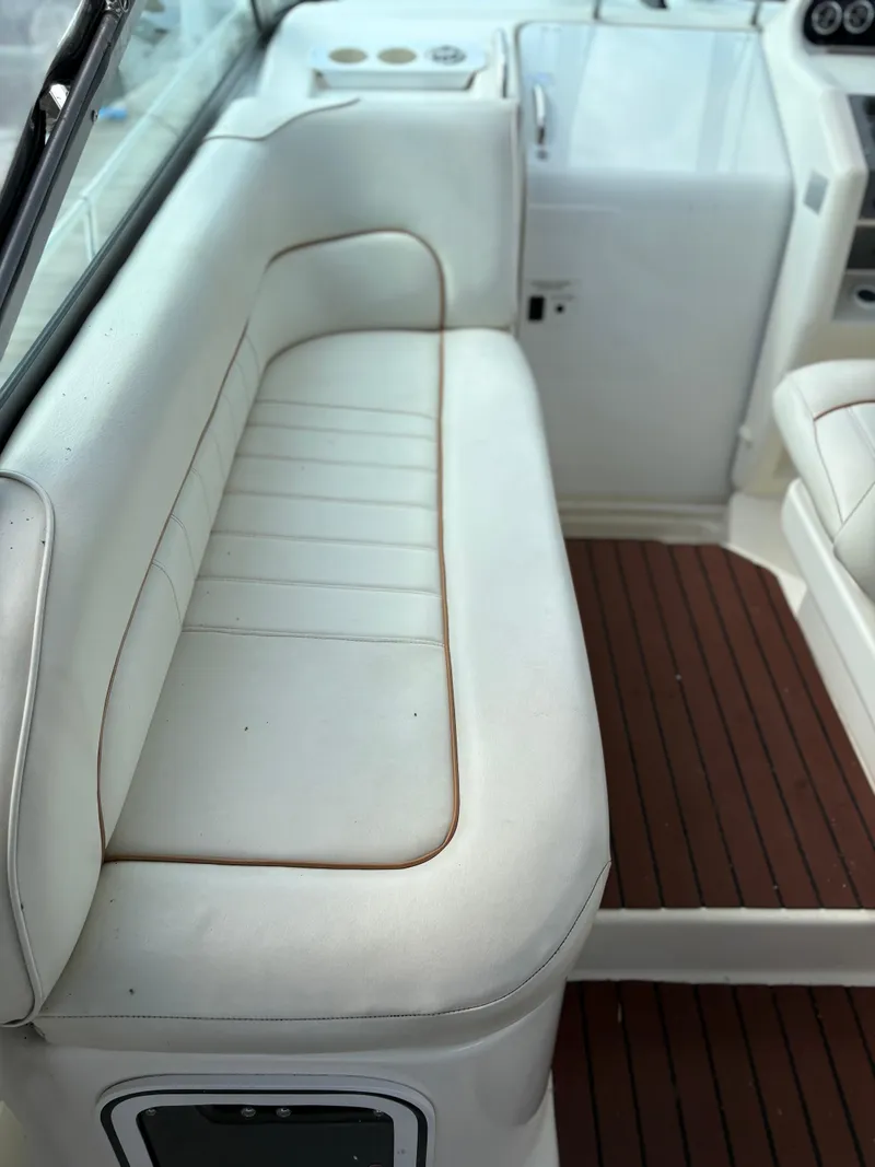Slide: The Image of 1996 Sea Ray 270 Sundancer interior with white seating and wood flooring. - 6
