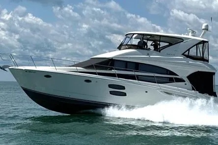 Slide: The Image of 2015 Meridian 441 Sedan yacht cruising on open water under a cloudy sky. - 1