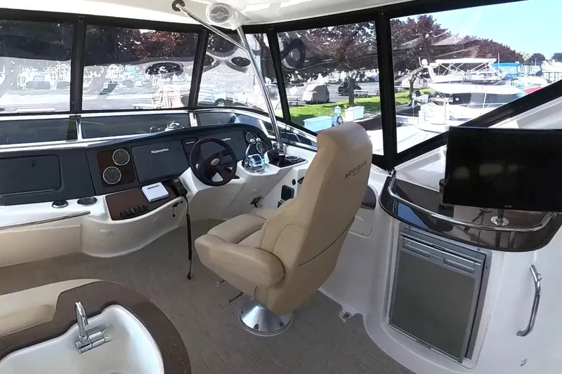 Slide: The Image of 2015 Meridian 441 Sedan yacht interior with helm, steering wheel, and navigation equipment. - 10