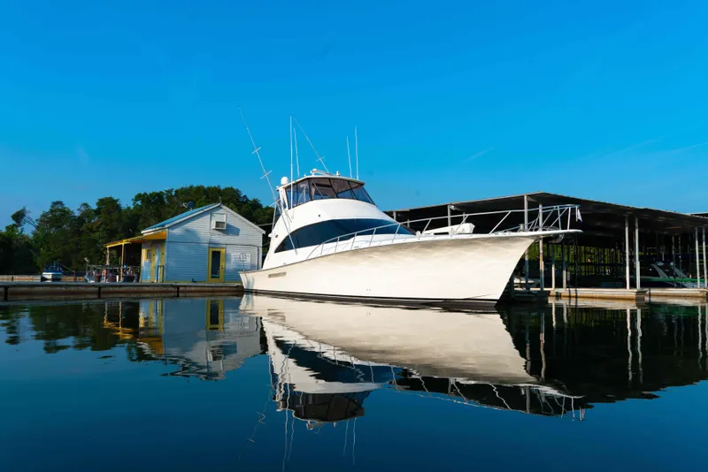 Slide: The Image of 1997 Ocean Yachts 60 Sport Fish docked by a marina under clear blue skies. - 14