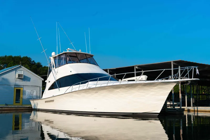 Slide: The Image of 1997 Ocean Yachts 60 Sport Fish boat docked on calm water under clear blue sky. - 15