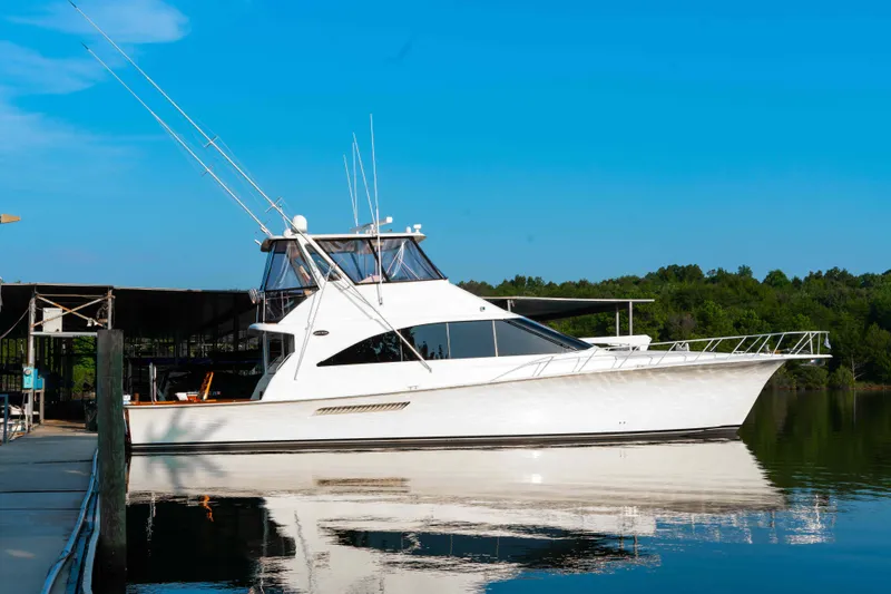 Slide: The Image of 1997 Ocean Yachts 60 Sport Fish boat docked on calm water under clear blue sky. - 16