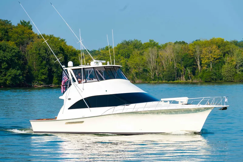 Slide: The Image of 1997 Ocean Yachts 60 Sport Fish cruising on a serene lake with lush green trees. - 2