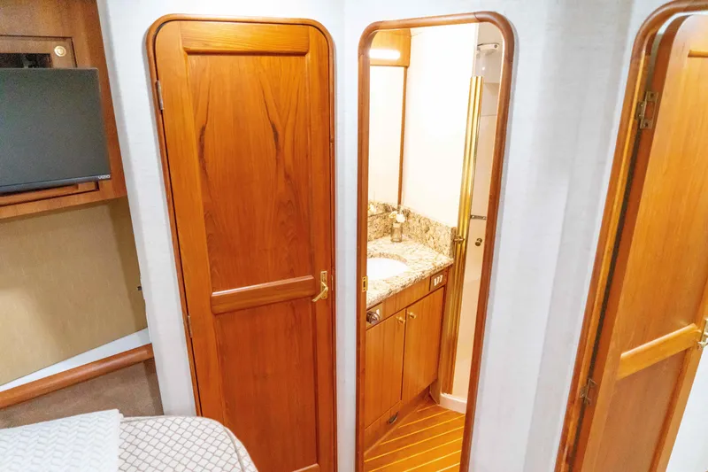 Slide: The Image of Interior of 1997 Ocean Yachts 60 Sport Fish, featuring wooden doors and a compact bathroom. - 47