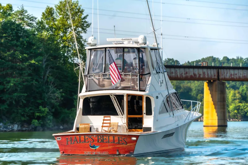 Slide: The Image of 1997 Ocean Yachts 60 Sport Fish boat cruising on a river near a bridge. - 9