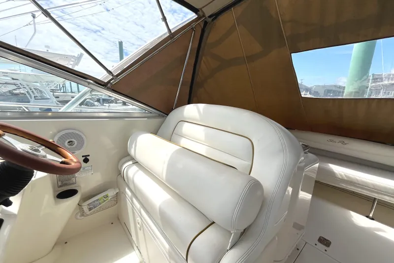 Slide: The Image of 2001 Sea Ray 290 Amberjack interior with white seating and steering wheel. - 12