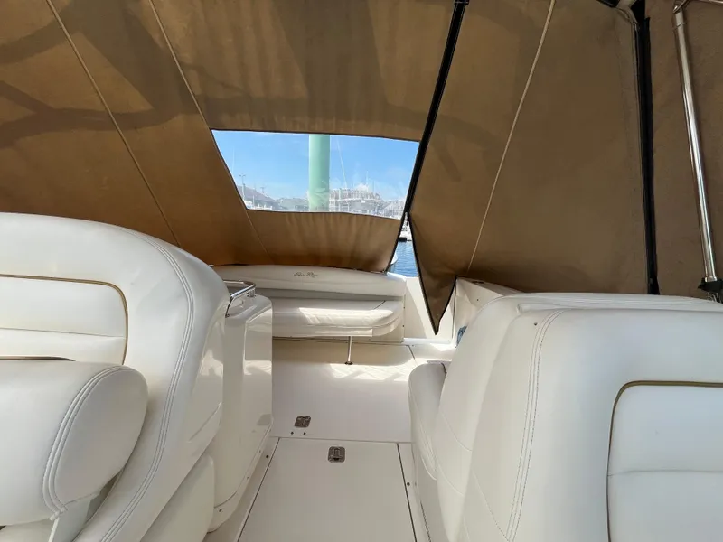 Slide: The Image of 2001 Sea Ray 290 Amberjack interior with white seating and tan canopy. - 13