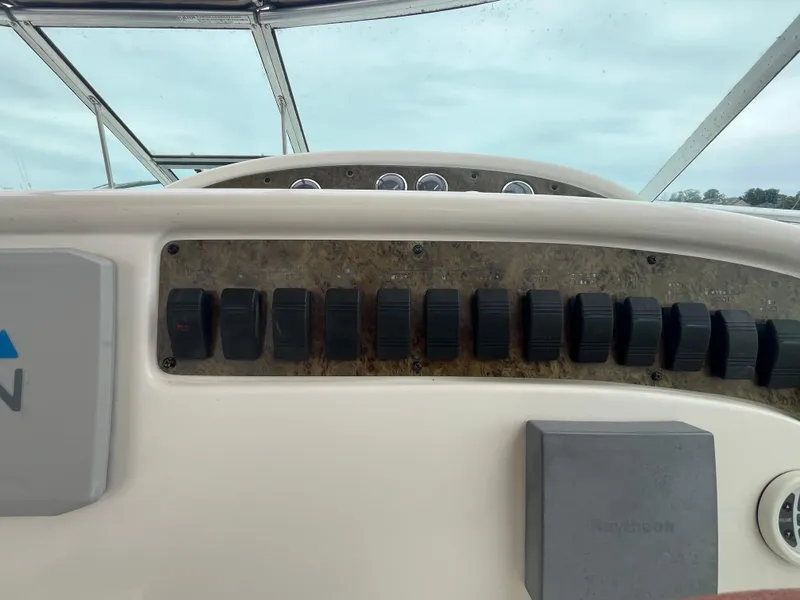 Slide: The Image of Dashboard of a 2001 Sea Ray 290 Amberjack boat with control switches and gauges. - 16