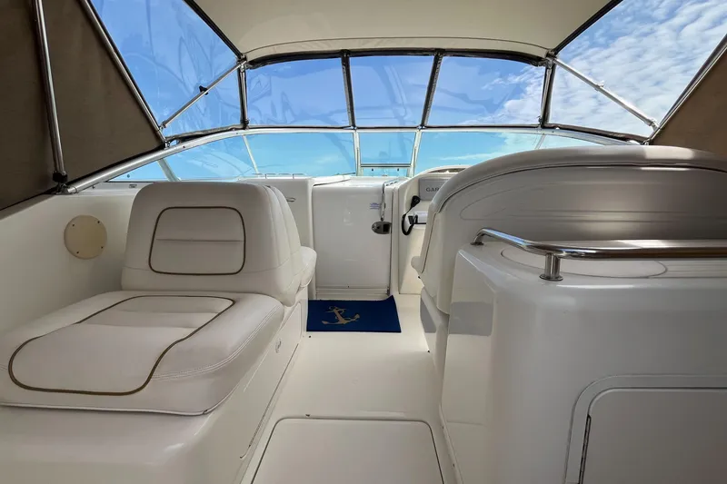 Slide: The Image of 2001 Sea Ray 290 Amberjack boat interior with white seating and clear canopy. - 20