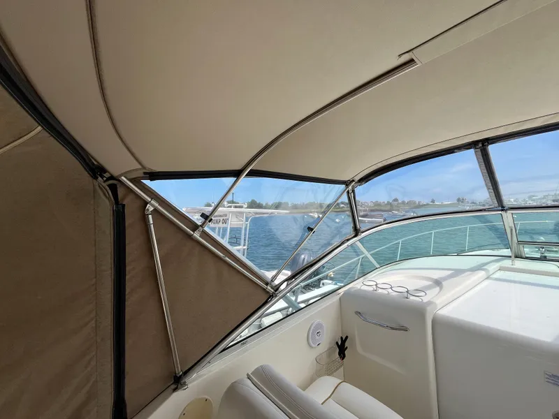 Slide: The Image of Interior view of 2001 Sea Ray 290 Amberjack boat with canopy and water backdrop. - 21