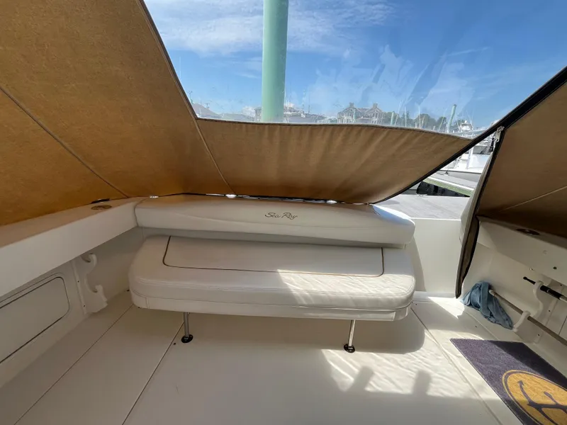 Slide: The Image of 2001 Sea Ray 290 Amberjack interior with cushioned seating and canopy, dockside view. - 29