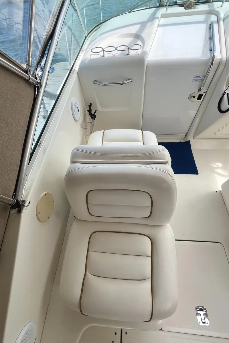 Slide: The Image of 2001 Sea Ray 290 Amberjack boat interior with white seating and control panel. - 32