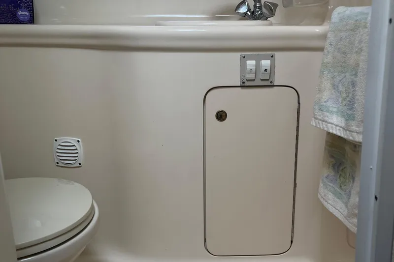Slide: The Image of 2001 Searay 29 Amber boat bathroom with toilet, sink, and storage cabinet. - 35