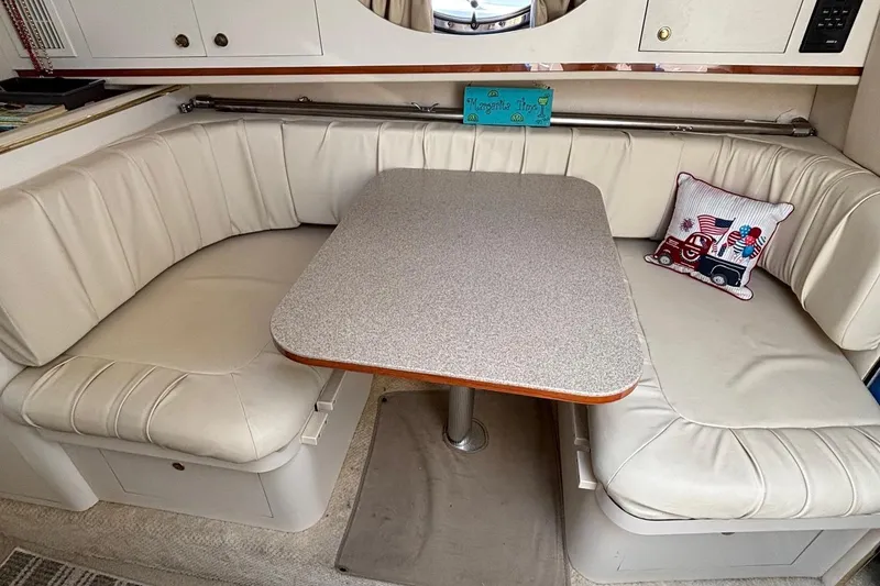 Slide: The Image of 2001 Searay 29 Amber boat interior with cushioned seating and table. - 37