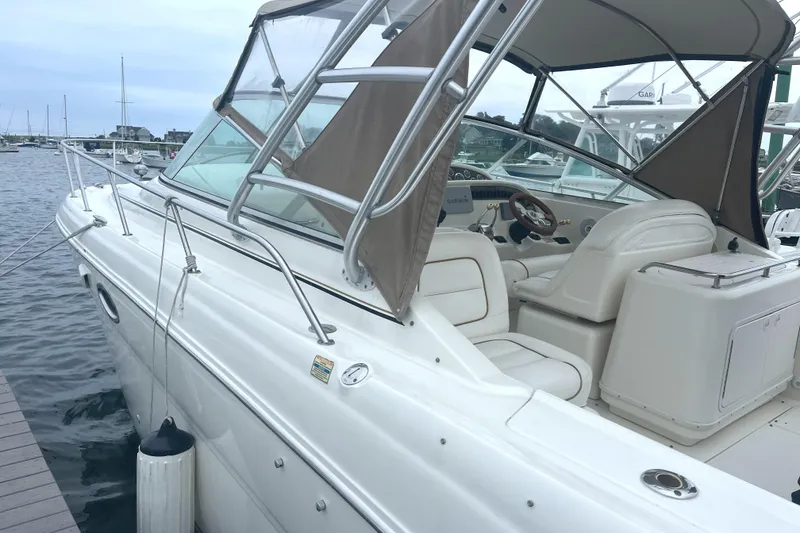 Slide: The Image of 2001 Sea Ray 290 Amberjack boat docked, featuring a spacious cockpit and elegant design. - 4