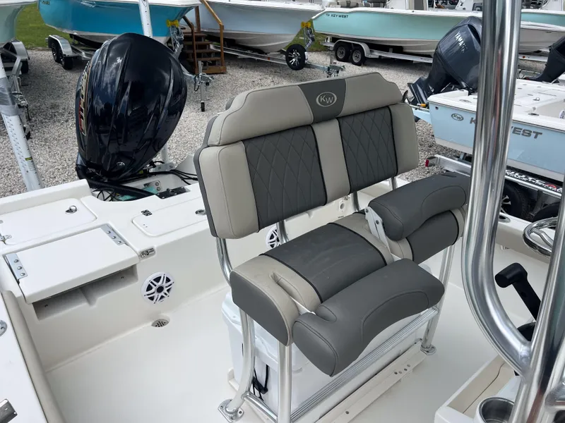Slide: The Image of 2026 Key West 230 Bay Reef boat interior with cushioned seating and outboard motor. - 7