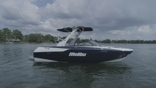 Slide: The Image of 2023 Malibu M220 boat on calm water under cloudy sky. - 25