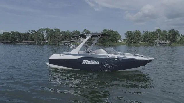Slide: The Image of 2023 Malibu M220 boat on a serene lake. - 28