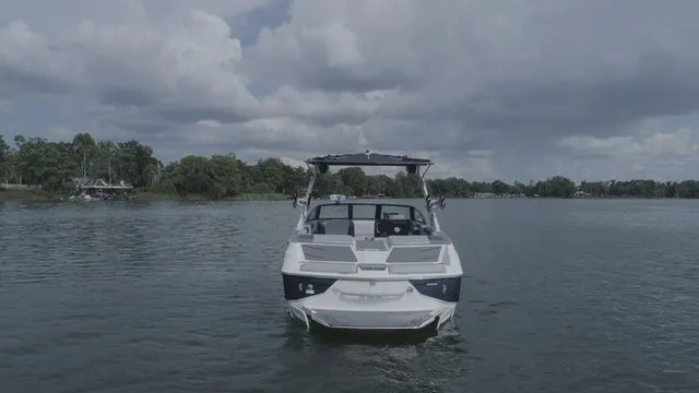 Slide: The Image of 2023 Malibu M220 boat on calm lake under cloudy sky. - 30