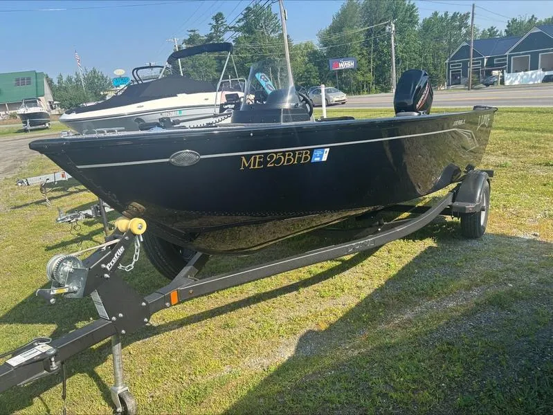 The Image of 2022 Lund 1650 Rebel XL boat on trailer, parked on grass. - 1