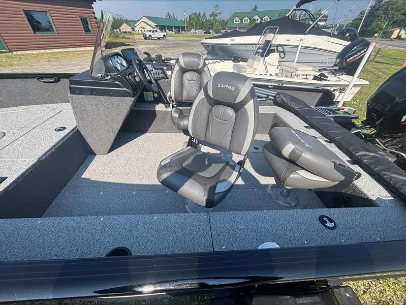 Slide: The Image of 2022 Lund 1650 Rebel XL boat interior with gray seating and steering console. - 4