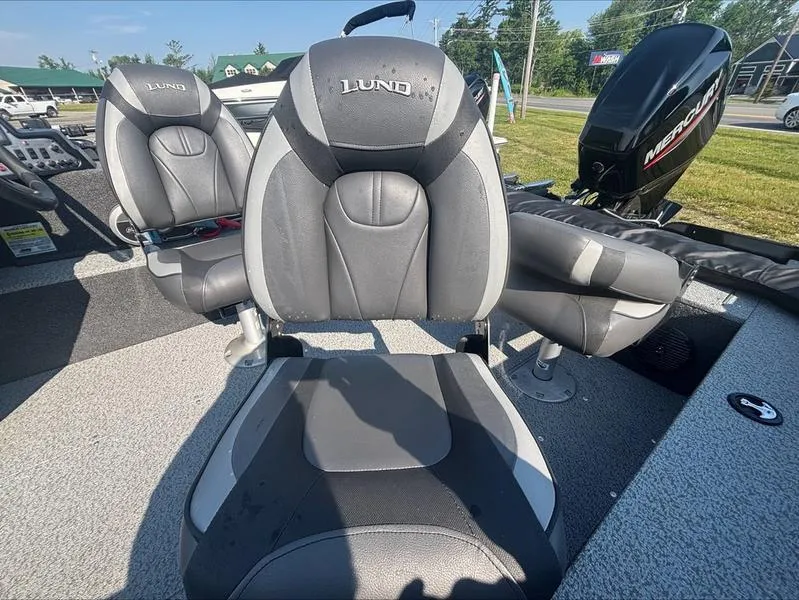 Slide: The Image of 2022 Lund 1650 Rebel XL boat interior with gray seats and Mercury engine. - 6
