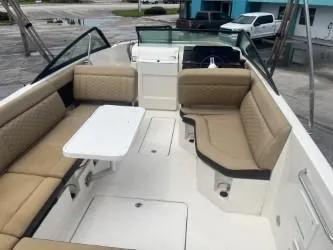 Slide: The Image of 2022 Sea Ray SDX 250 boat interior with beige seating and a white table. - 10